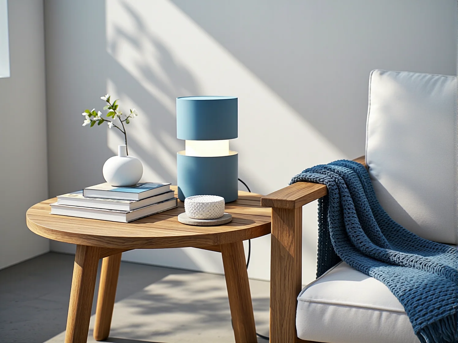 Minimalistyczne meble tarasowe w kolorze bieli na tle błękitnego oświetlenia punktowego LED.